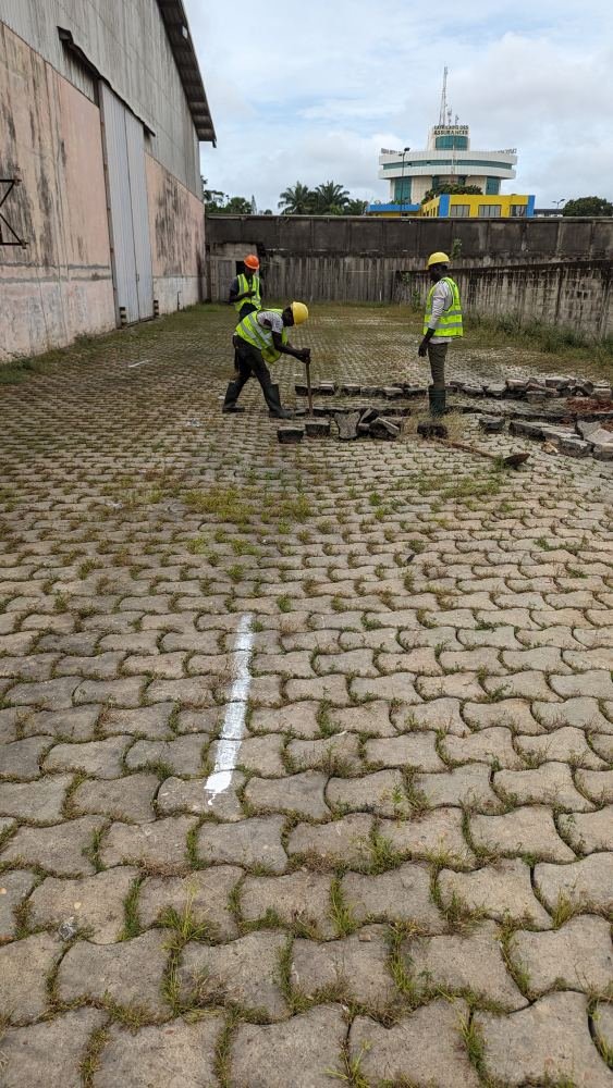 Techniciens marquant au sol le tracé de réseaux sur des pavés
